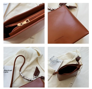 Détails d'un sac en cuir marron montrant la fermeture éclair et le foulard sur la poignée
