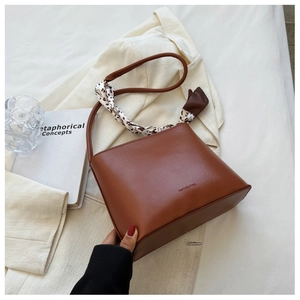 Détail d'un sac seau en similicuir marron orné d'un foulard en soie à pois stylé