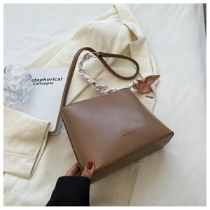 Vue détaillée du sac à bandoulière en cuir mat marron avec foulard décoratif en soie