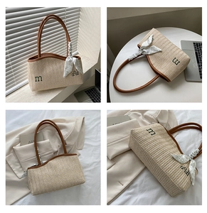 Detail of woven straw tote bag with brown leather trim and floral scarf handle wrap