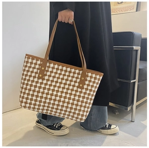 Detail der karierten Shopper-Tasche mit braunen Lederriemen und Goldnieten