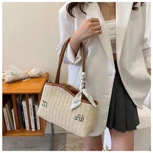 Vue détaillée d'un sac bandoulière en paille avec broderie et foulard en soie floral