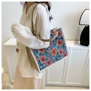 Close-up of floral print tote bag with natural hemp rope handles and woven texture