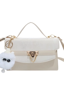 Modieuze crossbodytas in beige en abrikoos met gouden slot en pluche monsterhanger