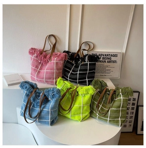 Detailed view of woven tote bags in five colors with fringe trim and leather straps