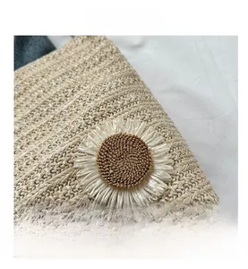 Detailed close-up of woven tote bag with large 3D white daisy flower and straw texture