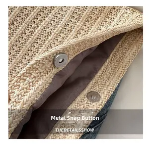 Detailed macro view of the silver magnetic snap closure on a woven straw tote bag