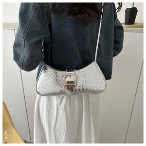 Détail du sac demi-lune argenté avec texture pied-de-poule et grande boucle dorée