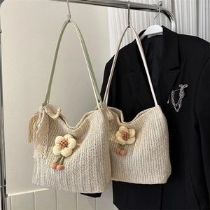 Detail of hand-woven straw tote bags with floral accents and lace bows for summer style