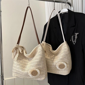 Detail of handwoven straw tote with daisy floral accents and lace bow decorations