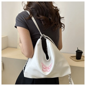 Detail of white leather shoulder bag with pink butterfly embroidery and chain strap