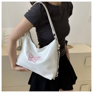 Detail of white PU leather hobo bag with pink butterfly embroidery and silver metal chain