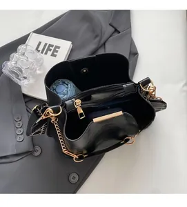 Macro view of black bucket bag interior showing spacious compartments and strap details