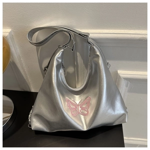 Close-up of silver hobo bag featuring pink butterfly embroidery and metallic chain detail