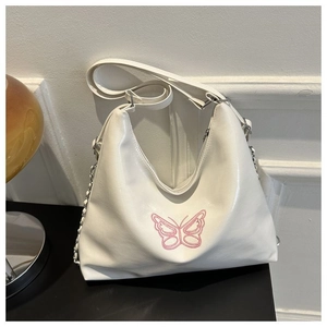 Detail of white PU bucket bag featuring pink butterfly embroidery and silver chain strap