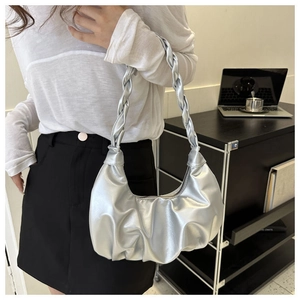 Detail der silbernen Metallic-Cloud-Tasche mit Falten-Struktur und geknotetem Riemen