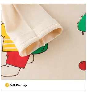 Détail de la couture du poignet et motif de dessin animé sur t-shirt enfant beige