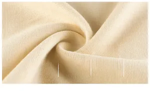 Close-up of soft beige knit fabric showing fine texture and breathable cotton fibers