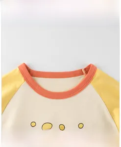 Detail von orangefarbenem Rundhalsausschnitt und Print des Kinder-Baumwoll-Patchwork-Shirts