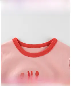 Détail du col de t-shirt rose en coton avec bordure rouge et imprimé SO HAPPY