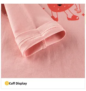 Détail de la couture des poignets et de l'imprimé fruit sur le t-shirt en coton rose pour fille