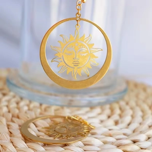 Macro detail of Bohemian gold sun goddess earrings with hollow sun face design