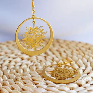 Bohemian gold sun goddess drop earrings with S925 hooks on a natural straw texture