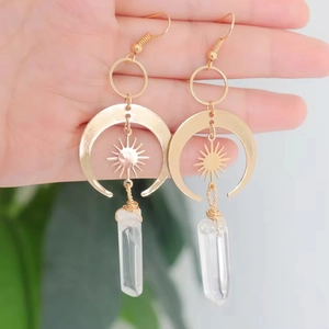 Gold celestial earrings featuring crescent moon and sun charm with clear crystal column