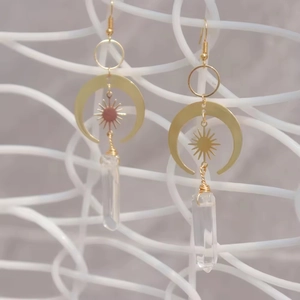 Detail of gold celestial earrings with moon charms and crystal prisms for women