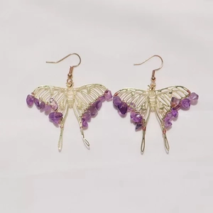 Handmade gold butterfly earrings with purple amethyst stone chips on white background