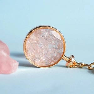 Dettaglio del portachiavi a bottiglia dei desideri con cristallo rosa e cornice dorata
