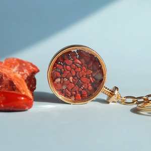 Dettaglio di portachiavi con pietre di cristallo rosso e cornice in metallo dorato