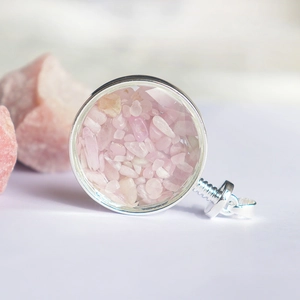 Gedetailleerde macro van een ronde kristallen wensfles hanger met roze kwartsstenen