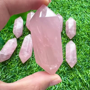 Set aus acht doppelendigen rosa Rosenquarz-Säulen auf einem grünen Rasenuntergrund