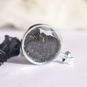 Macro-opname van zilveren ronde hanger gevuld met zwarte kristallen en geslepen glas