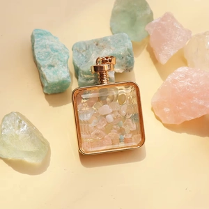 Macro detail of square gold crystal perfume bottle pendant with colorful natural gemstones