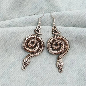 Orecchini a serpente cobra argento gotico con scaglie vintage su tessuto grigio