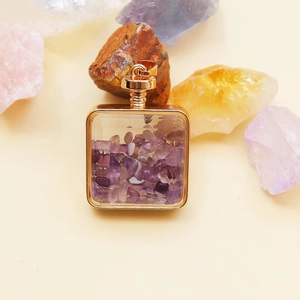 Detail of square gold perfume pendant filled with natural purple amethyst crystal stones