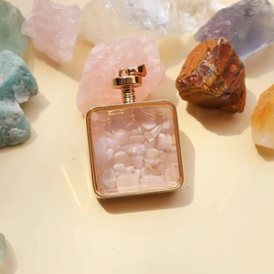 Detailed view of square gold frame pendant filled with healing pink quartz stone chips