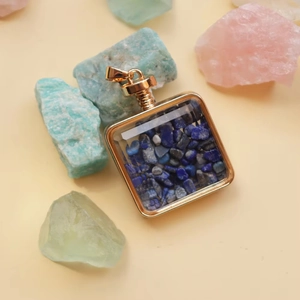 Macro shot of square gold perfume bottle pendant with blue lapis lazuli stones