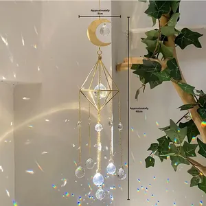 Detailed view of K9 crystal sun catcher with gold moon and prism rainbows on white wall