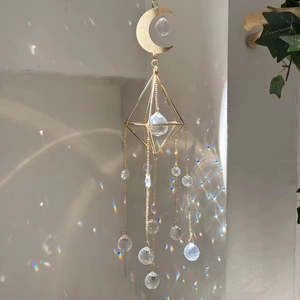 Detail of metal sun catcher with K9 crystal spheres reflecting rainbow light on wall