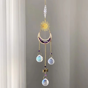 Detail of sun and moon crystal suncatcher with clear faceted balls and purple stones