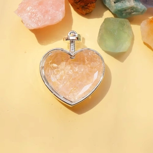 Dettaglio ciondolo a cuore porta profumo con frammenti di pietre di cristallo rosa