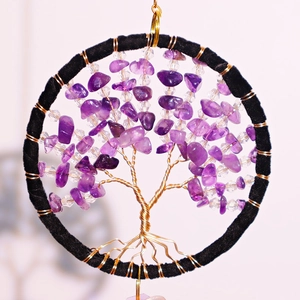 Macro detail of Tree of Life car ornament with purple crystals and gold wire weaving