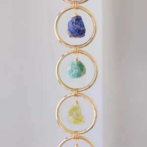 Handmade wall hanging with natural crystal raw stones and golden metal rings decor
