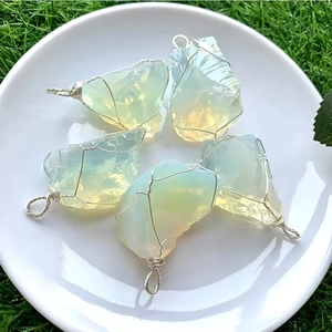 Vue détaillée de pendentifs en opale brute enveloppés de fil métallique fait main