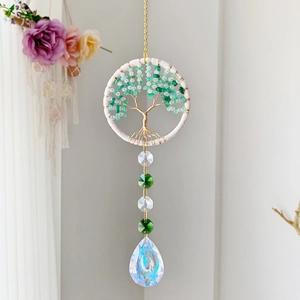 Détail d'attrape-soleil arbre de vie avec éclats de cristal vert et grand prisme goutte d'eau