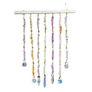 Colorful crystal suncatcher with natural raw stones and star accents on a wooden bar