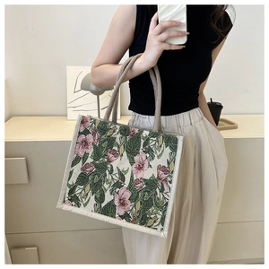 Close-up of vintage floral tapestry pattern and woven rope handle on a large linen tote bag